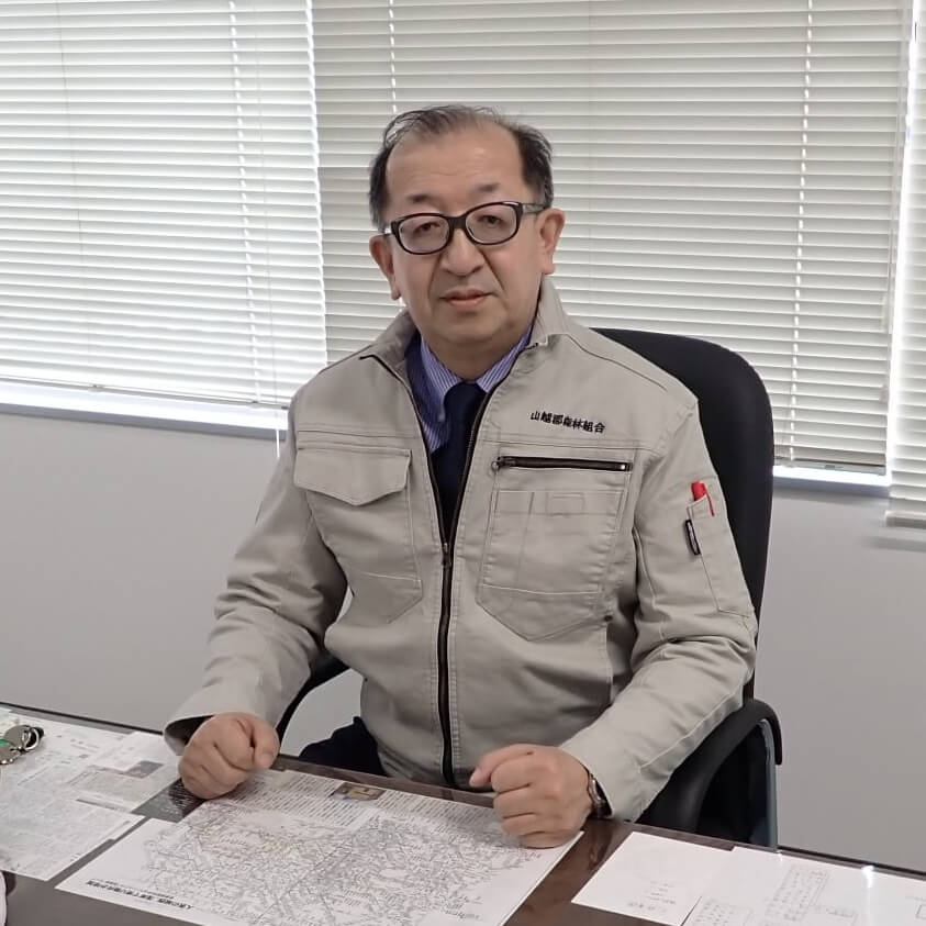 机に地図を広げ、インタビューに答える山越郡森林組合の組合長